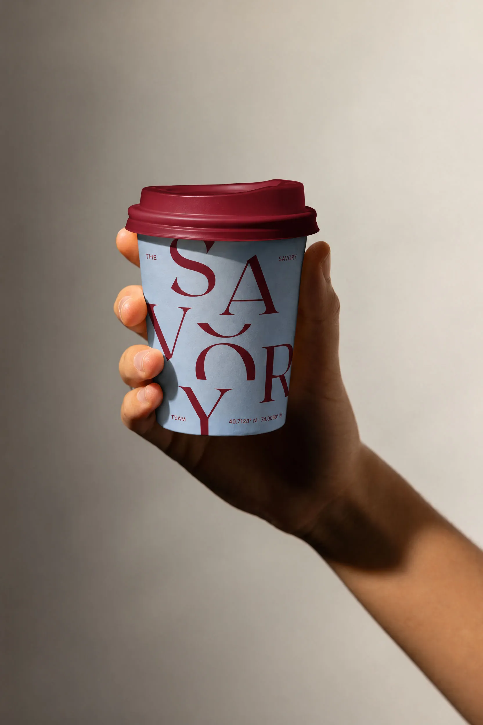 Baby blue coffee cup with a wax red lid and SAVORY stacked in wax red capitals