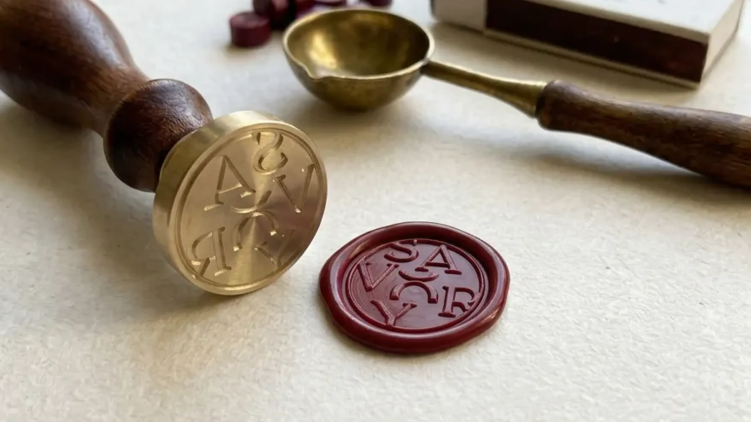 Brass wax seal stamp beside a wax red seal pressed with SAVORY stacked in a circle